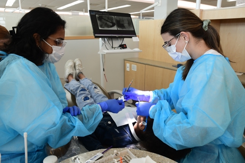 Photo of dental students treating patient during Give Kids A Smile kickoff Feb. 6 in Houston